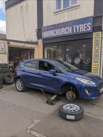 Blue Ford Fiesta jacked up outside Hornchurch Tyres for tyre fitting in Essex
