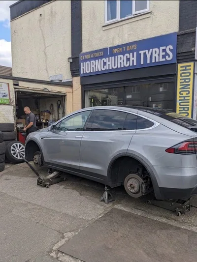 Tesla Model X SUV jacked up for tyre replacement at Hornchurch Tyres, Hornchurch Road