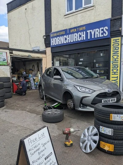 Silver Toyota Yaris having front tyre replaced outside Hornchurch Tyres on Hornchurch Road